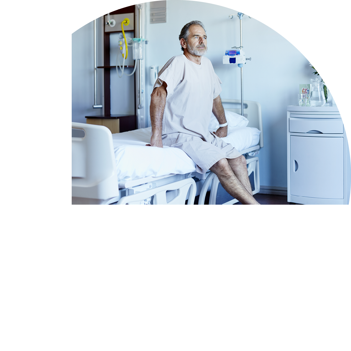 Thoughtful mature man looking away while sitting on bed in hospital ward